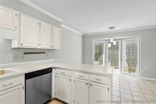 a kitchen with white cabinets and a window