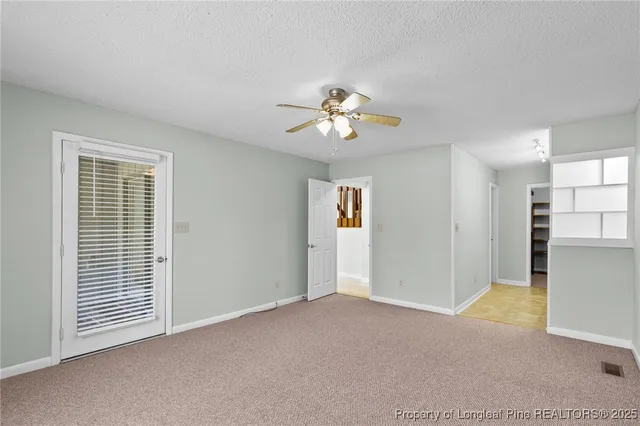 a view of a livingroom with a chandelier fan and windows