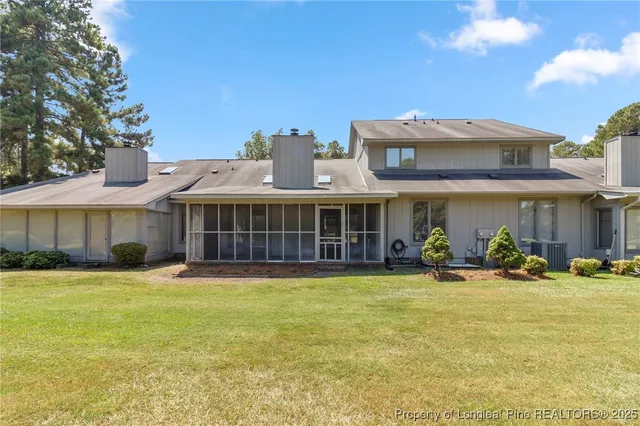 a view of a house with a yard and sitting area