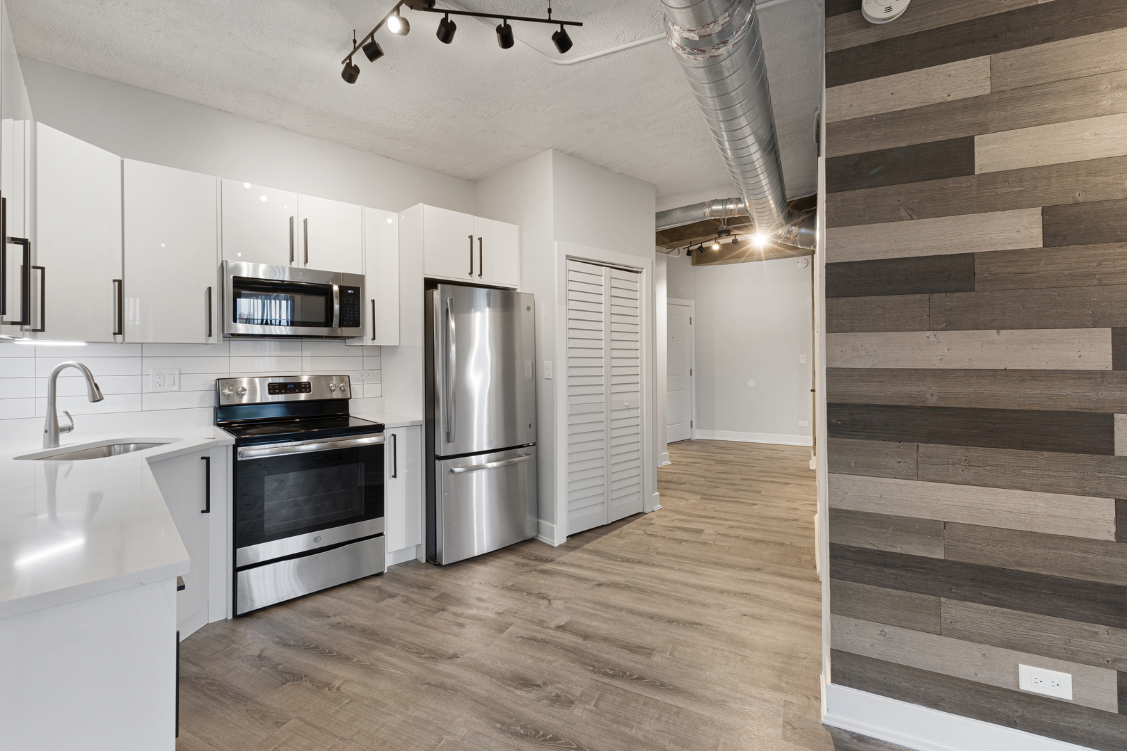 7645 North Sheridan Road, Unit 514 Chicago, IL 60626 - Photo 2 of 17 a kitchen with granite countertop a refrigerator and a stove top oven