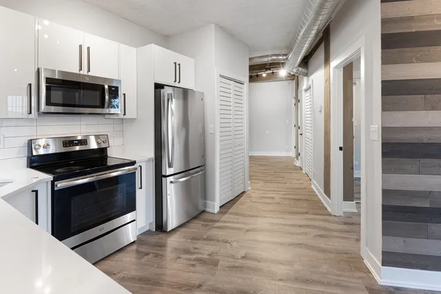 a kitchen with stainless steel appliances a stove microwave and a refrigerator