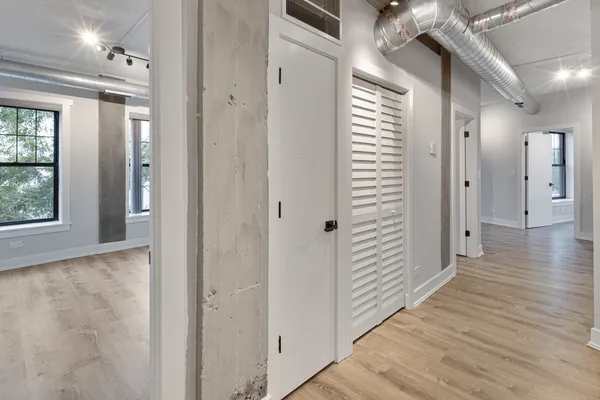 a view of a hallway with wooden floor and staircase