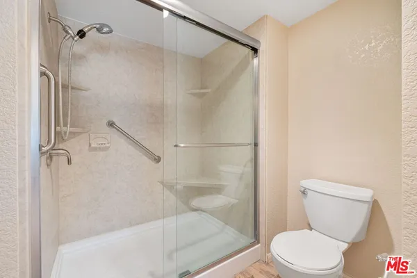 a white toilet sitting next to a bath tub