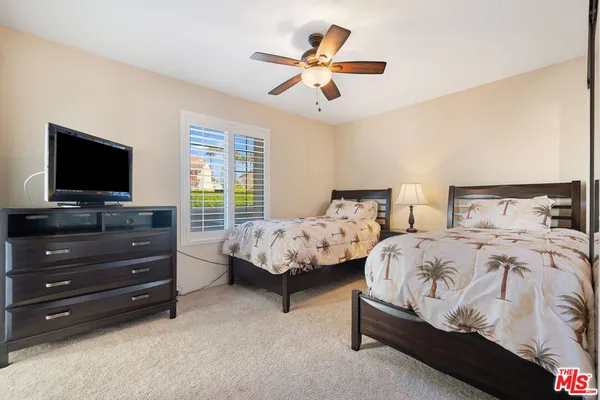 a bedroom with two beds and a flat screen tv