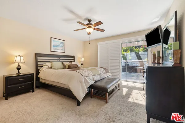 a bedroom with a bed flat screen tv and a large window