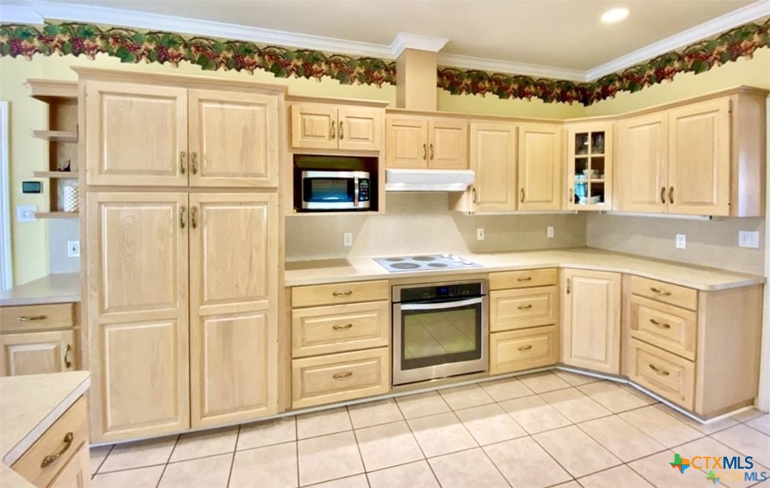 415 South Trinity Street Edna, TX 77957 - Photo 13 of 46 a kitchen with granite countertop white cabinets and white appliances