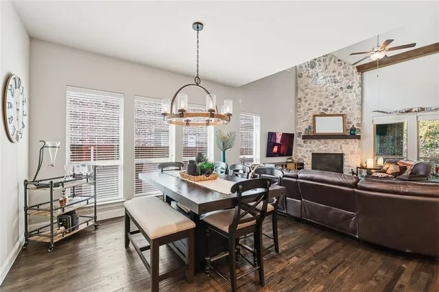 a kitchen with a dining table chairs and wooden floor
