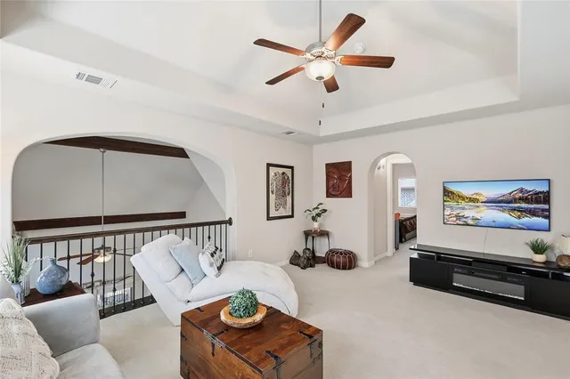a living room with furniture stairs and a large window