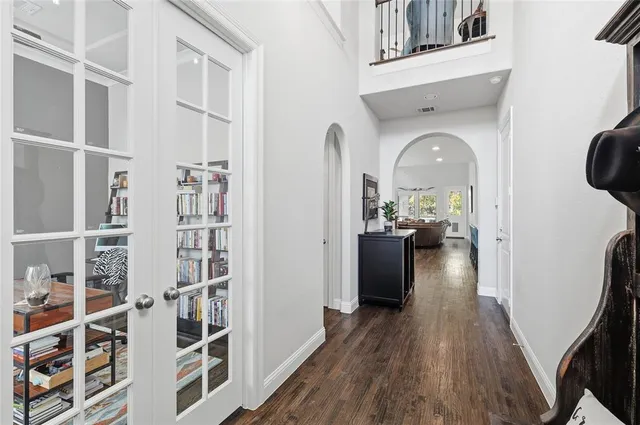 a view of a living room with wooden floor and a book shelf
