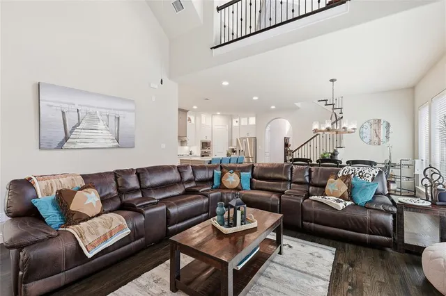 a view of a dining room and livingroom with furniture wooden floor and a chandelier