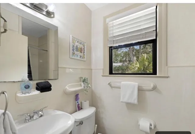 a bathroom with a sink mirror and toilet