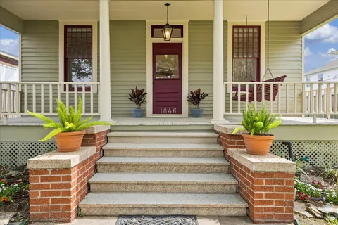 a front view of a house with a garden and trees