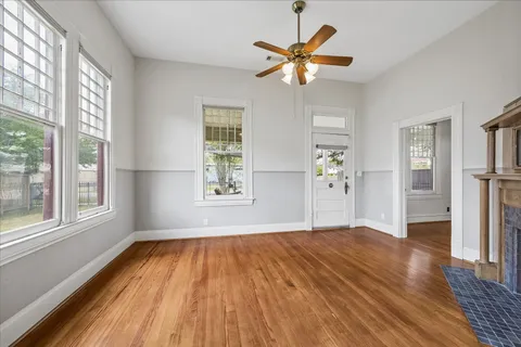 a view of an empty room with window and wooden floor