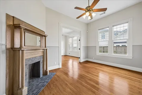 a view of an empty room with window and wooden floor