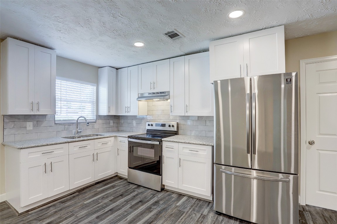 515 Main Street Pasadena, TX 77506 - Photo 3 of 10 a kitchen with stainless steel appliances granite countertop a refrigerator sink and white cabinets