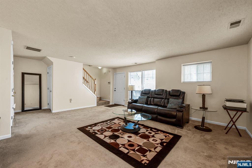 159 Market Street, Unit 1411 Newark, NJ 07102 - Photo 5 of 19 a living room with furniture and a rug