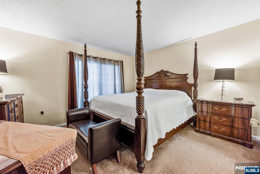 159 Market Street, Unit 1411 Newark, NJ 07102 - Photo 9 of 19 a bedroom with a bed dresser and a window