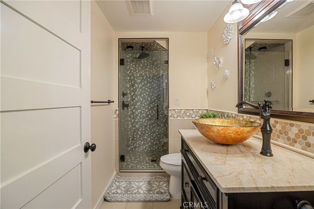 a view of a patio with couches table and chairs under an umbrella with a small yard