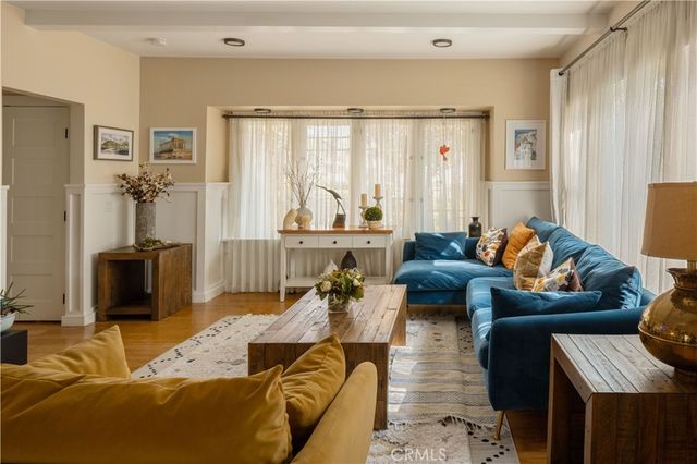 a living room with furniture wooden floor and a large window