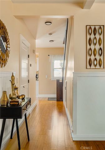 a view of a hallway with wooden floor and furniture
