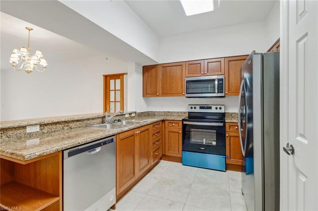 a kitchen with stainless steel appliances granite countertop a refrigerator stove and sink