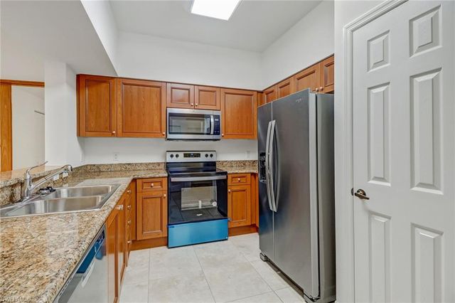 a kitchen with stainless steel appliances granite countertop a refrigerator stove and sink
