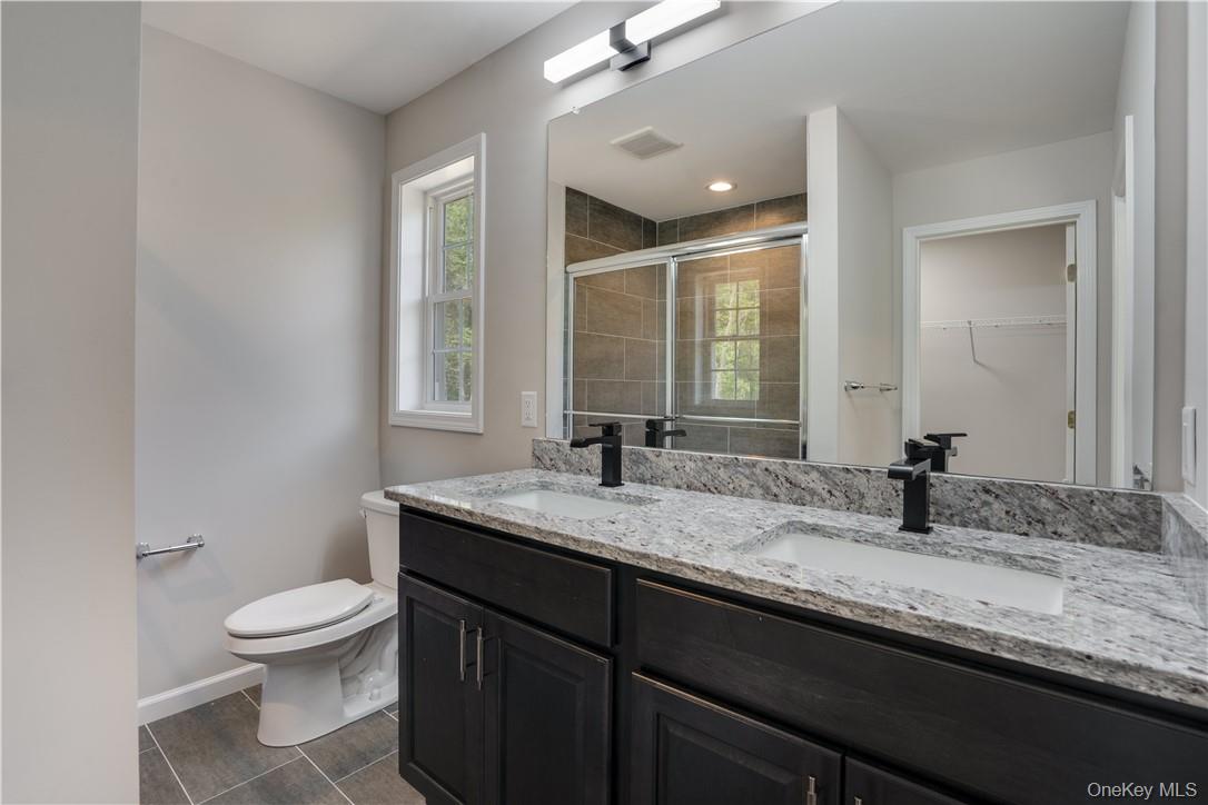 991 Freedom Road Pleasant Valley, NY 12569 - Photo 13 of 23 a bathroom with a granite countertop sink a toilet and a mirror
