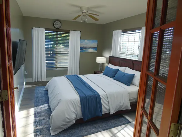 a bedroom with a bed closet and a flat tv screen