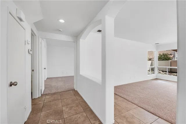 a view of a hallway to rooms and stairs