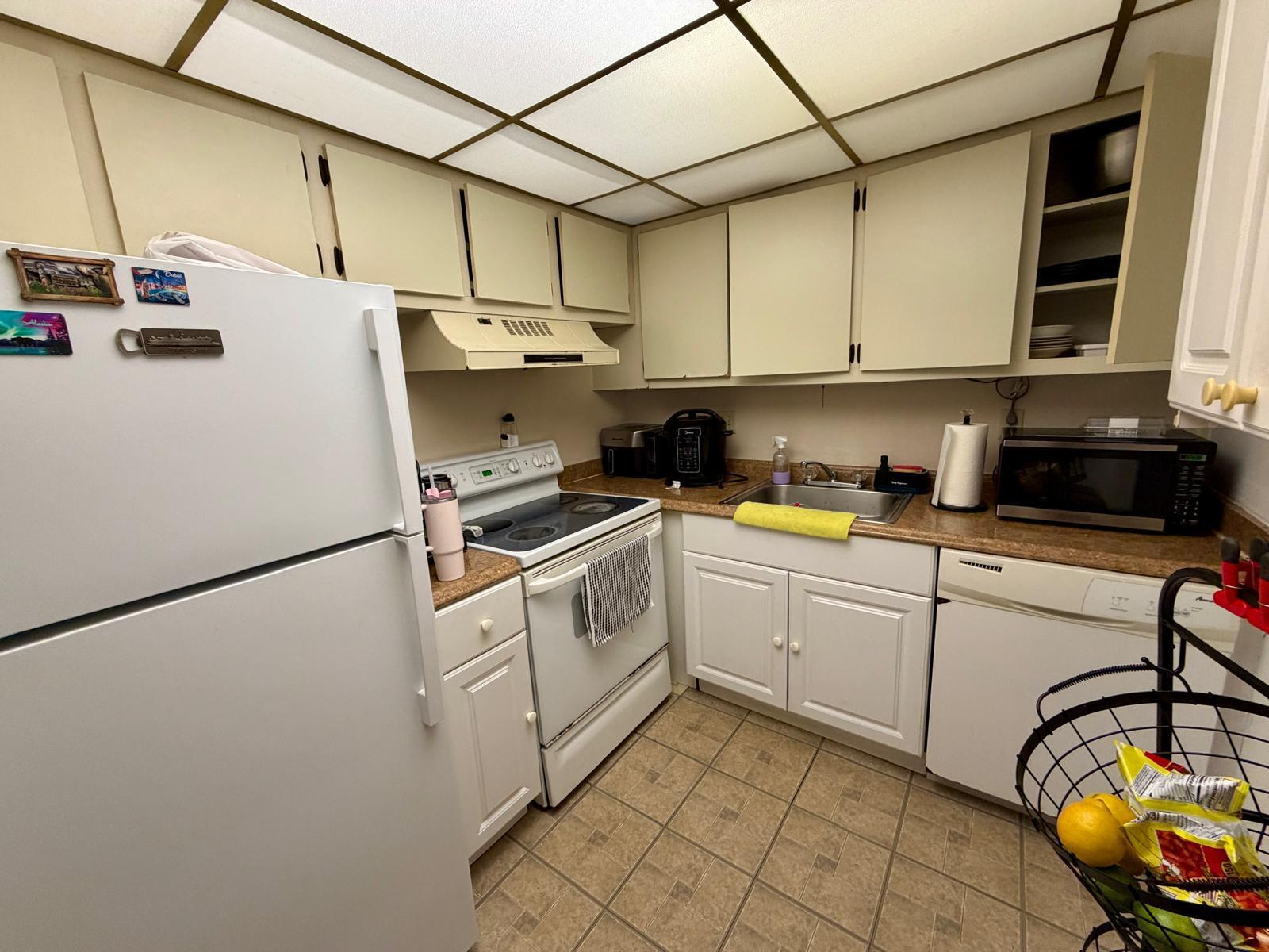 2000 Springdale Boulevard, Unit 102 Palm Springs, FL 33461 - Photo 3 of 11 a kitchen with a white cabinets and white appliances