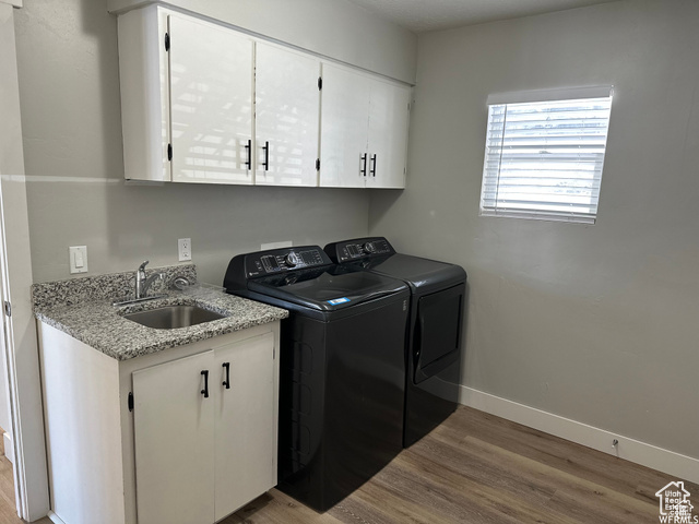 702 North 100 West Logan, UT 84321 - Photo 11 of 58 Laundry room with baseboards, washing machine and clothes dryer, a sink, cabinet space, and wood finished floors