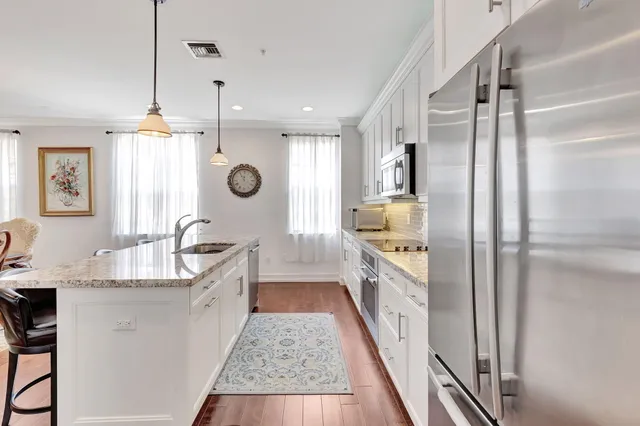a large kitchen with a lot of counter space and a wooden floor