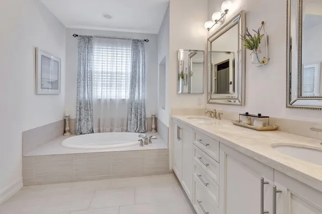 a bathroom with a granite countertop tub sink and mirror