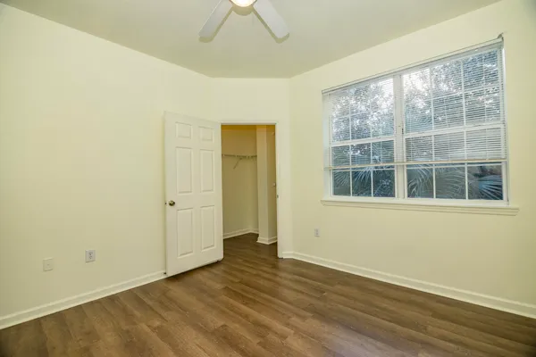an empty room with wooden floor and windows