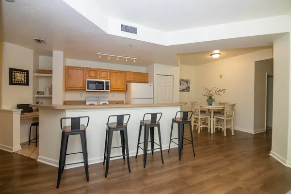 a kitchen with lots of chairs and wooden floor