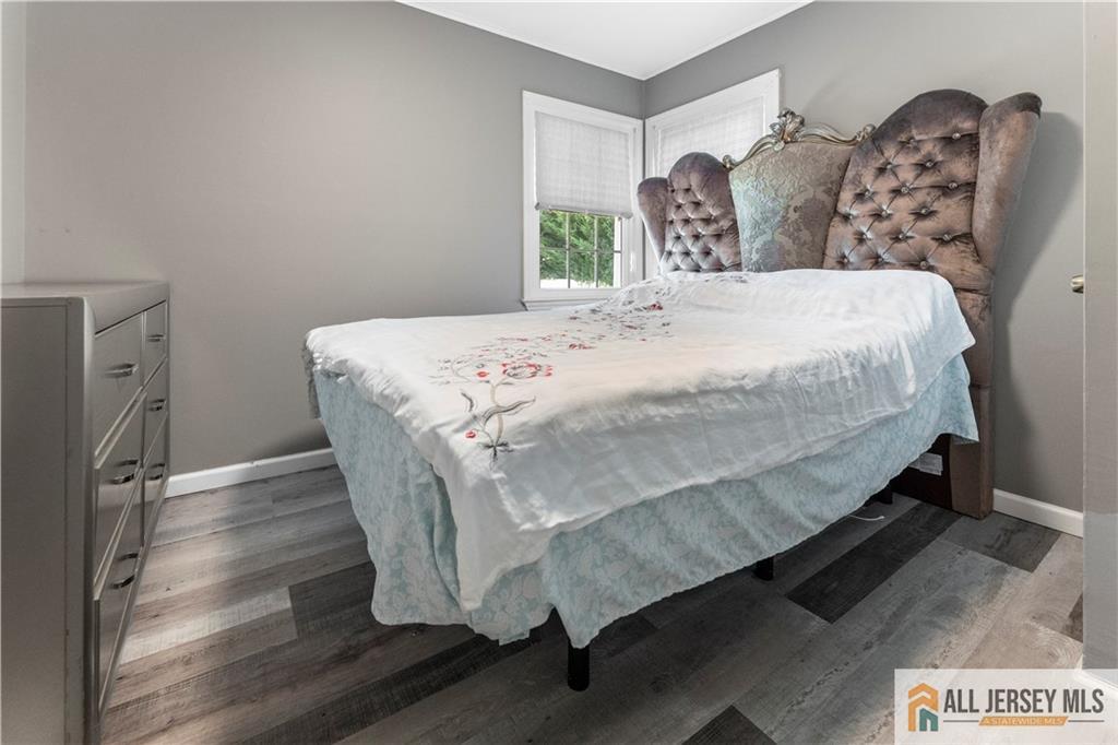 4 Burnham Road East Brunswick, NJ 08816 - Photo 15 of 25 a large bed sitting in a bedroom next to a window with wooden floor
