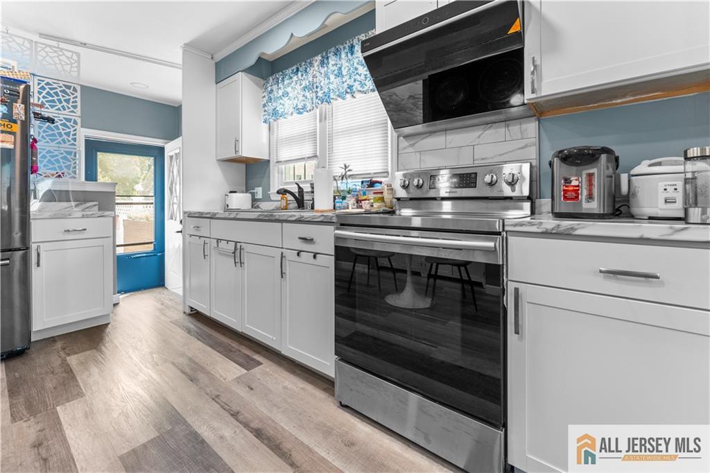 4 Burnham Road East Brunswick, NJ 08816 - Photo 8 of 25 a kitchen with stainless steel appliances granite countertop a stove microwave and sink