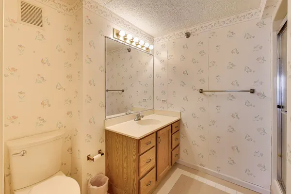 a bathroom with a sink a toilet and shower