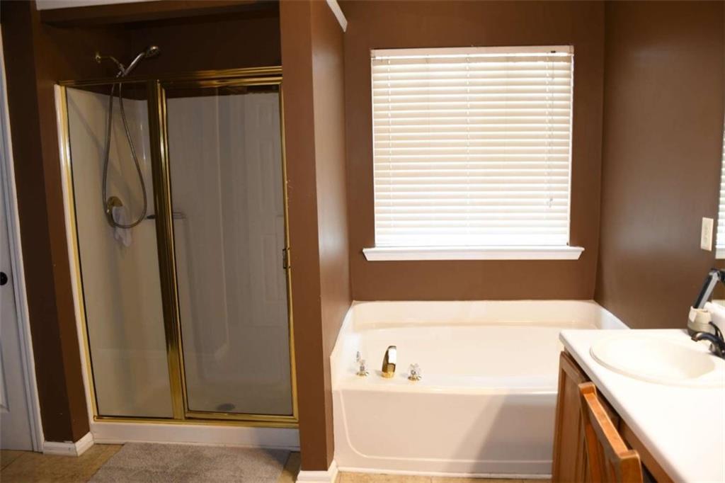 355 Magnolia Walk Lane Atlanta, GA 30349 - Photo 16 of 27 a bathroom with a bathtub and a sink