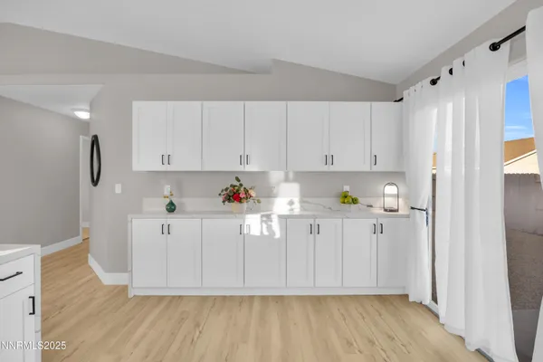 a kitchen with stainless steel appliances granite countertop a refrigerator sink and white cabinets