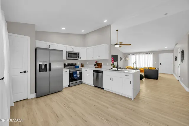 a kitchen with a refrigerator a sink dishwasher with a stove and cabinets