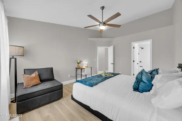 a bedroom with a large bed and a chandelier