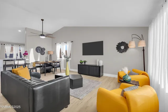 a living room with furniture a flat screen tv and kitchen view