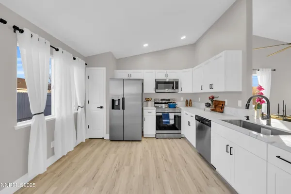 a kitchen with white cabinets and stainless steel appliances
