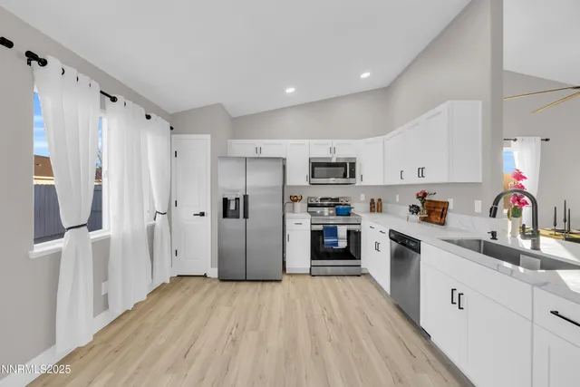 a kitchen with white cabinets and stainless steel appliances