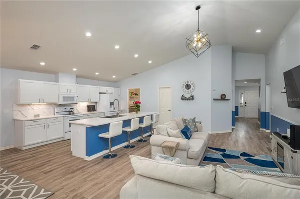 a living room with kitchen island furniture and a kitchen view