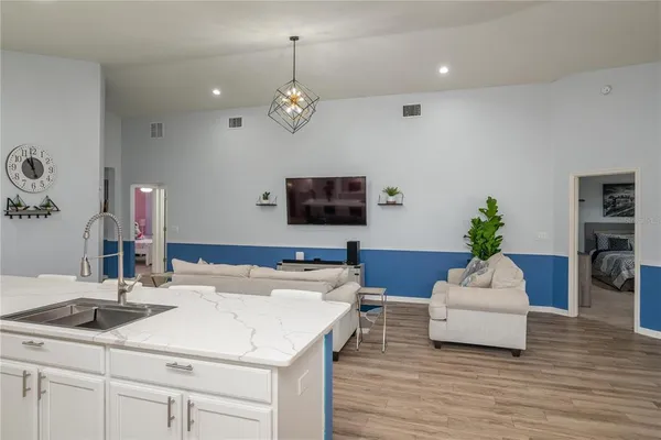 a living room with kitchen island furniture and a flat screen tv
