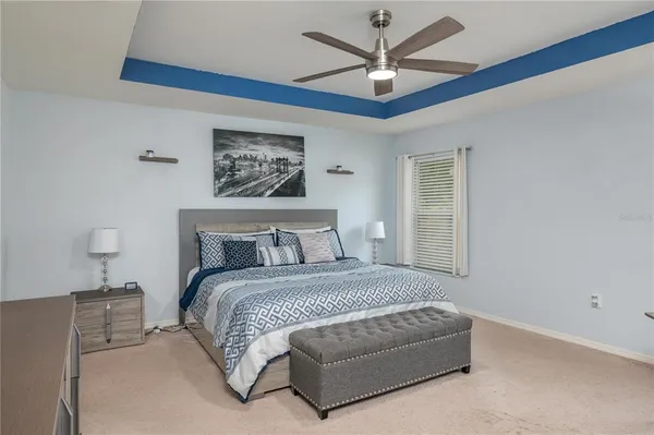 a bedroom with a large bed chandelier and a window