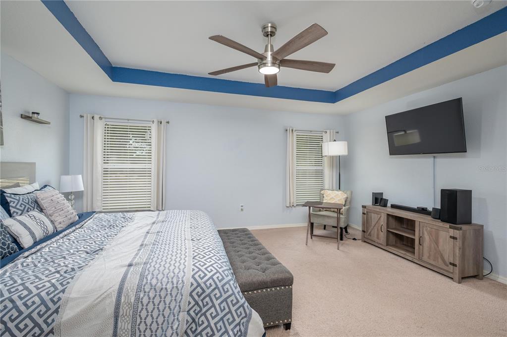 501 Interlock Street Lake Alfred, FL 33850 - Photo 21 of 35 a bedroom with a bed a flat screen tv and couches