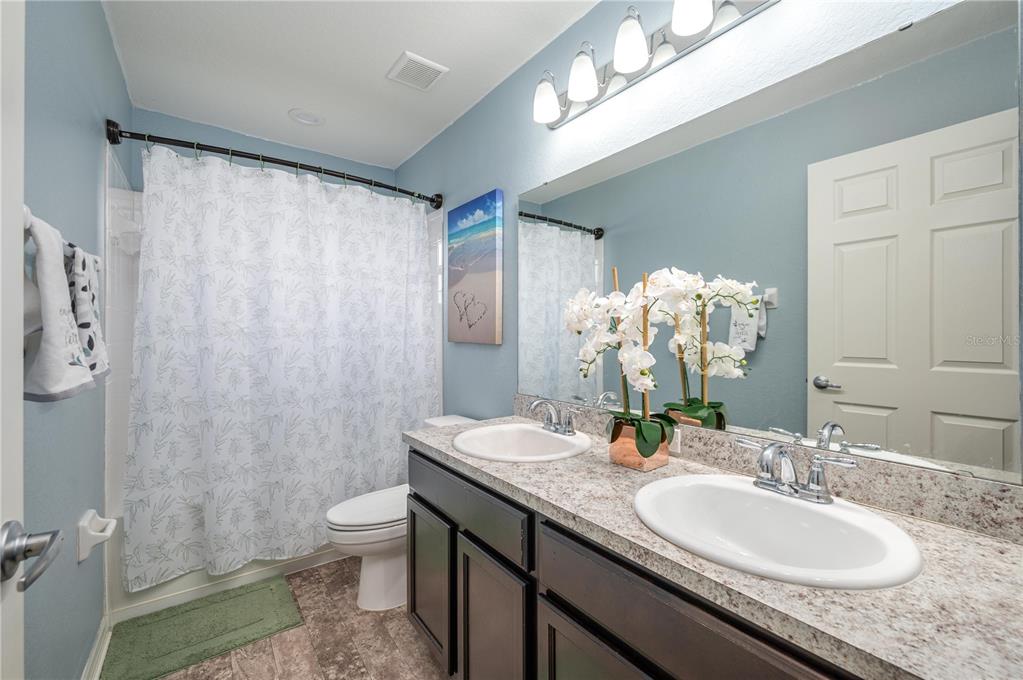 501 Interlock Street Lake Alfred, FL 33850 - Photo 27 of 35 a bathroom with a granite countertop sink a toilet and a mirror